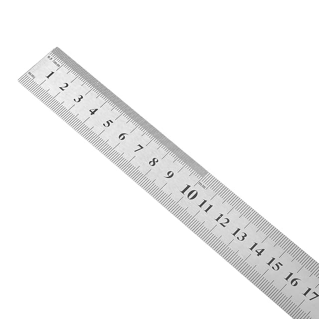 Bauster metal rule laid on a workbench alongside a pencil